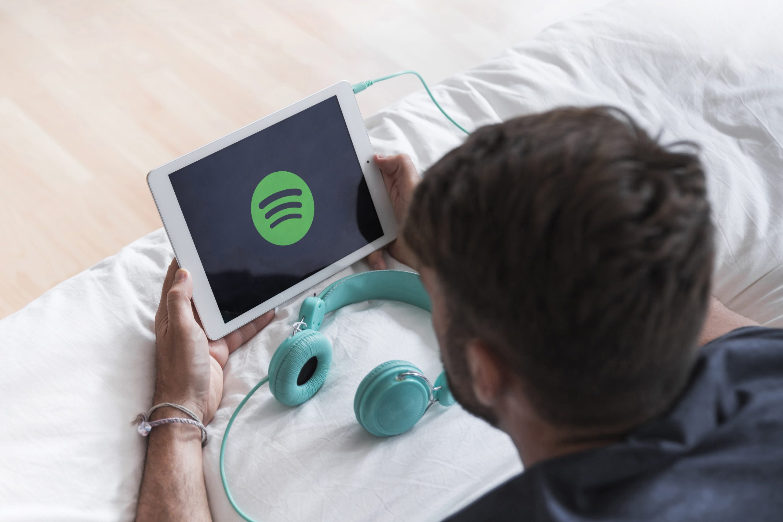 A man holding a tablet with the Spotify logo on the screen