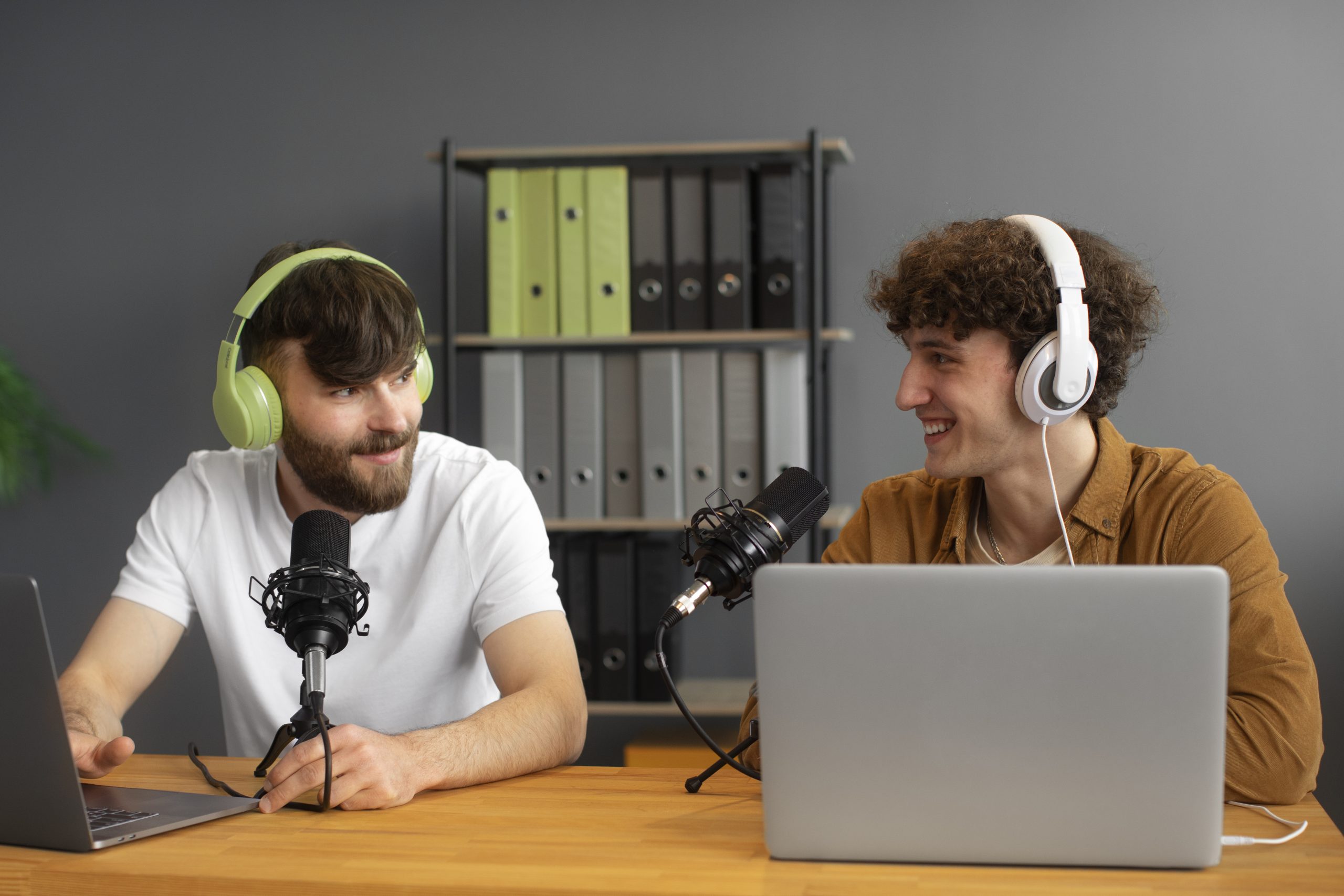 Two smiling young men recording a podcast